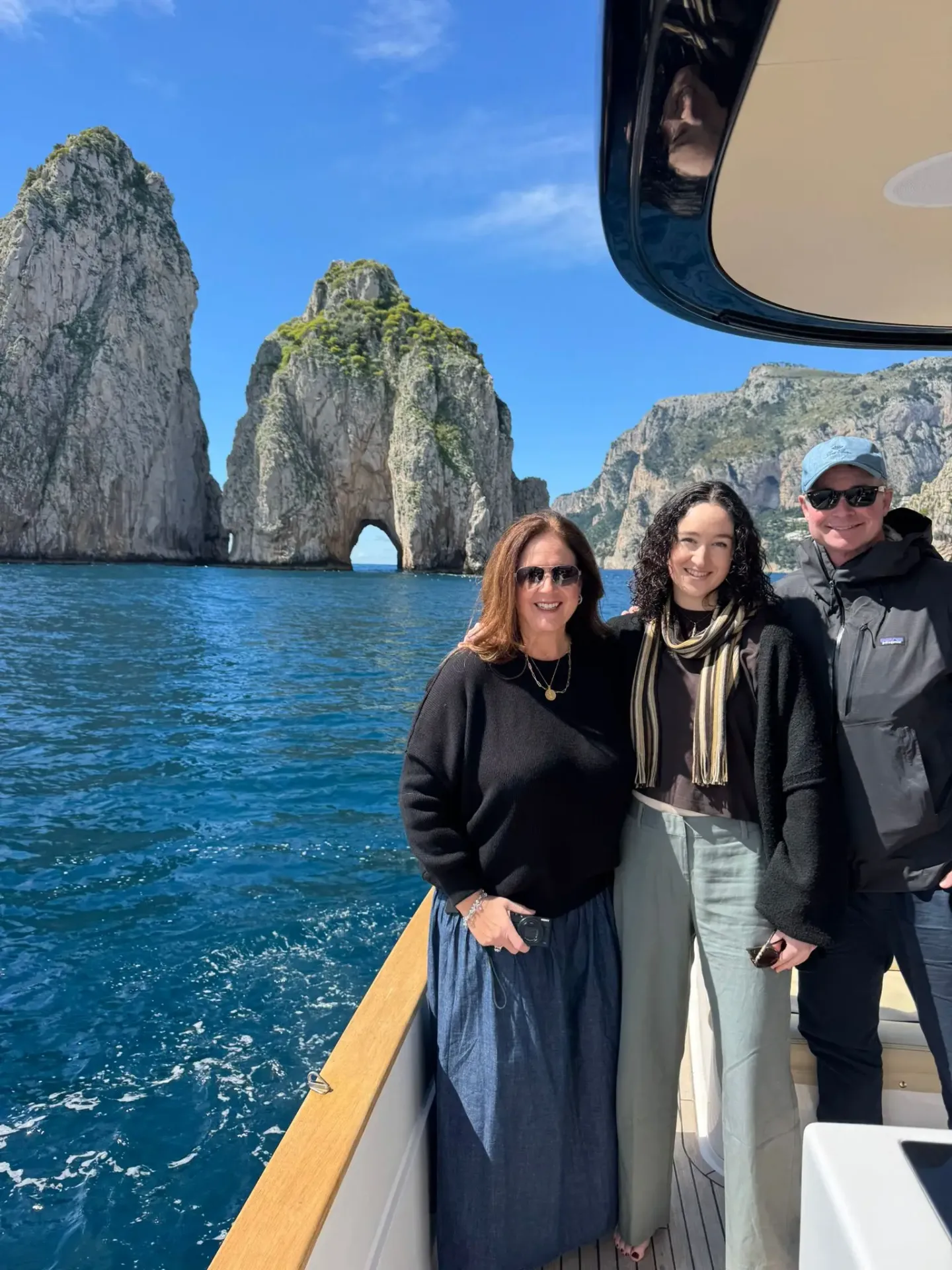 Famiglia in barca davanti ai Faraglioni di Capri